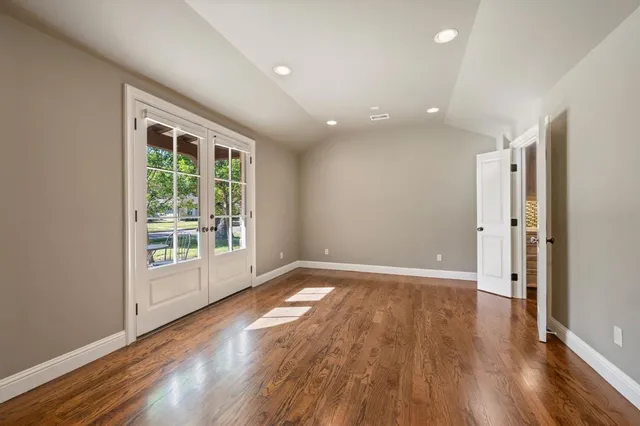 a view of an empty room with wooden floor and staircase
