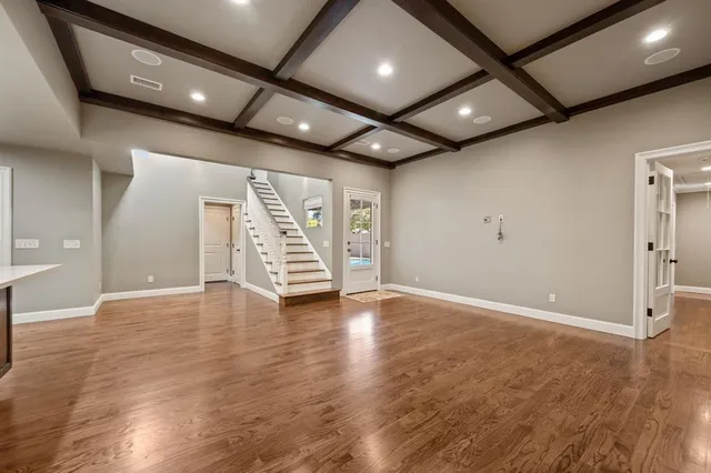 a kitchen with stainless steel appliances granite countertop a refrigerator a sink dishwasher and a stove with wooden floor