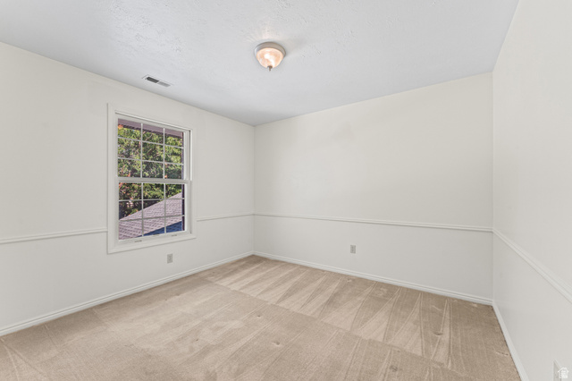 8441 Rua Branco Drive Sandy, UT 84093 - Photo 33 of 47 Bright secondary bedroom featuring neutral wall finishes, wood-finish flooring with linear plank detailing, and a large double-hung window with exterior views