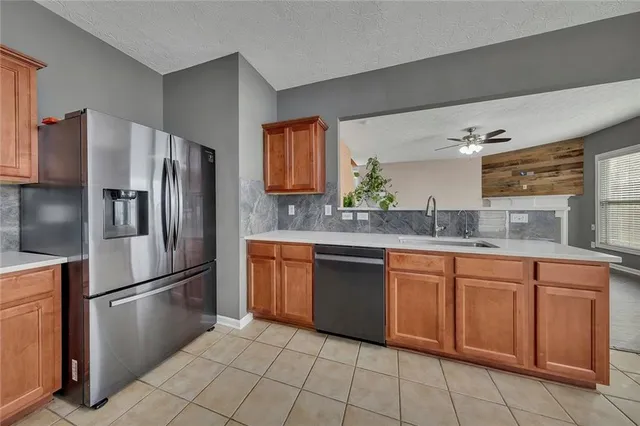 a kitchen with stainless steel appliances granite countertop a refrigerator sink and cabinets