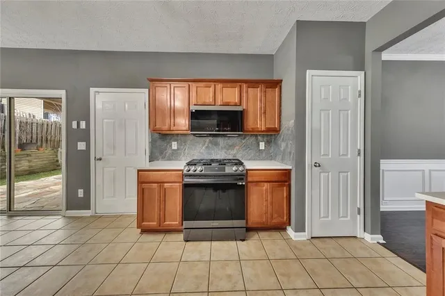a kitchen with stainless steel appliances granite countertop a stove a sink and a refrigerator