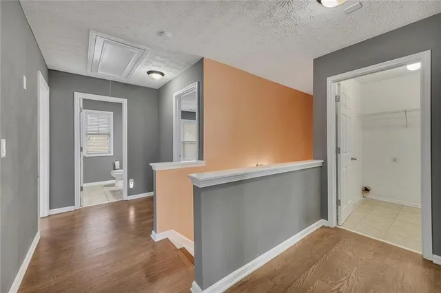 a view of a hallway with wooden floor and cabinet