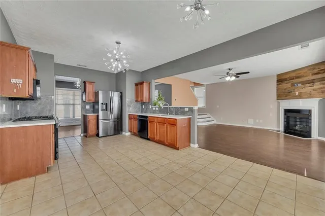 a large kitchen with stainless steel appliances granite countertop a stove sink and cabinets