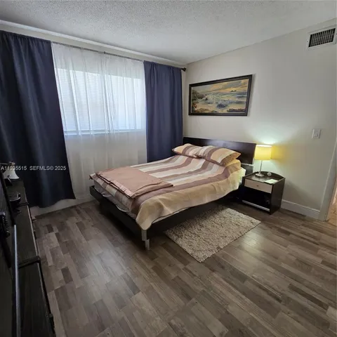 a bedroom with a bed and a flat tv screen