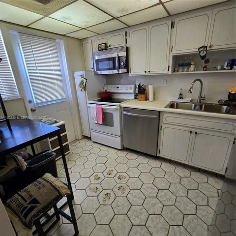 a kitchen with a sink cabinets and appliances