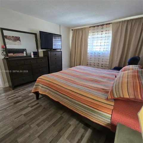 a bedroom with a bed and a television