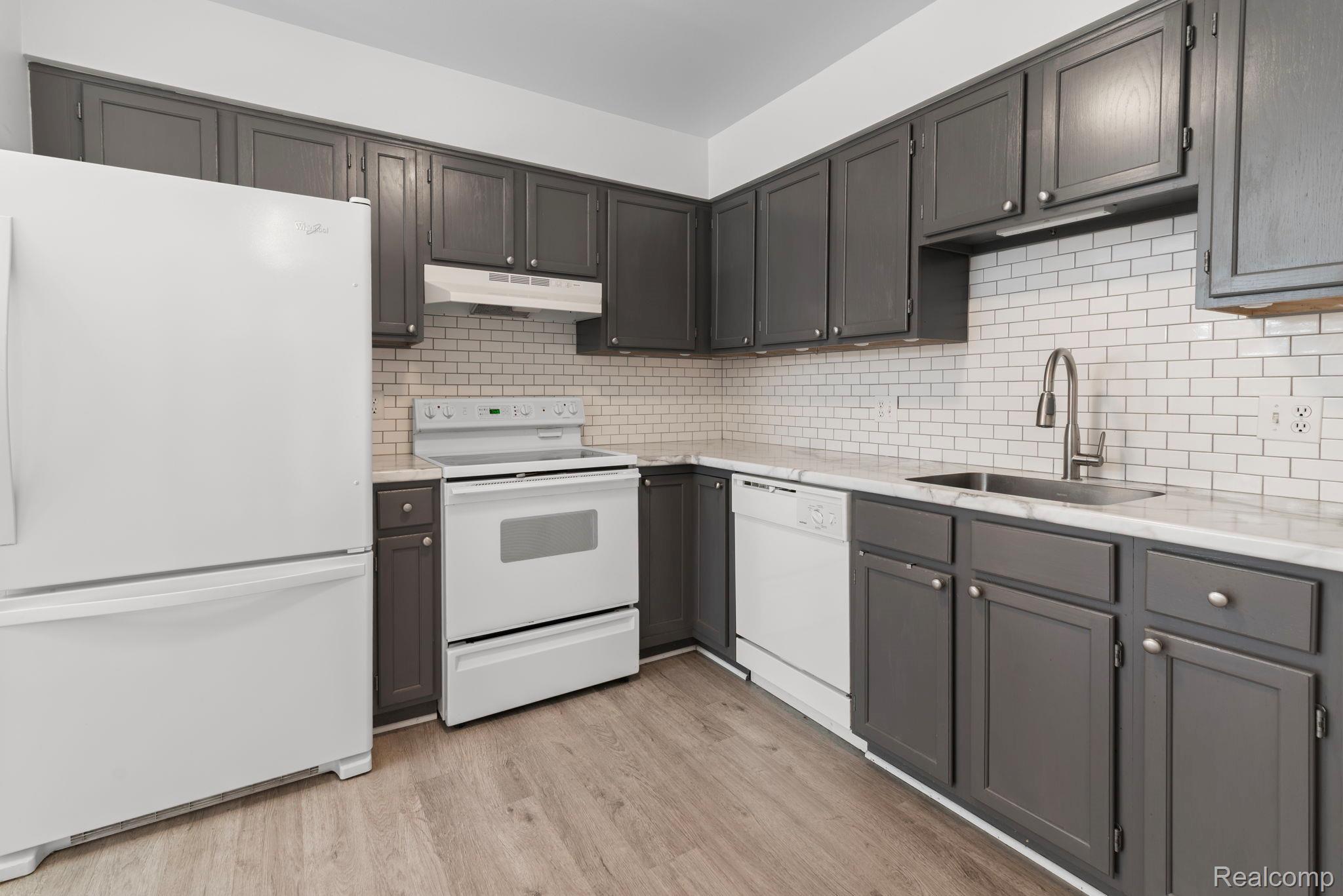 424 Baldwin Avenue, Unit 81 Rochester, MI 48307 - Photo 6 of 25 Enjoy a recently renovated kitchen featuring all sparkle white appliances and light colored decorative wood floor. With the most recent renovation being new kitchen cabinet knobs.