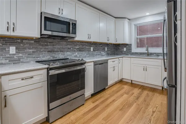 a kitchen with granite countertop wooden cabinets stainless steel appliances and a sink