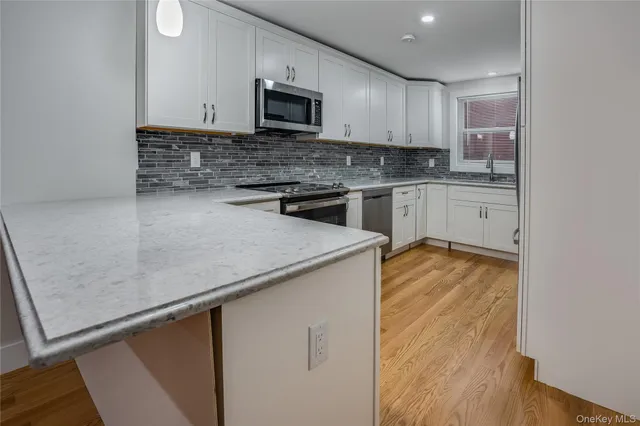 a kitchen with stainless steel appliances a microwave a sink and cabinets