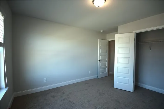 an empty room with a hallway and a window