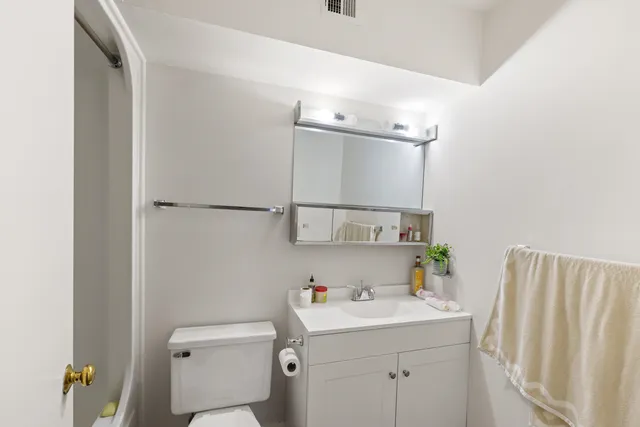 a bathroom with a sink vanity mirror and toilet