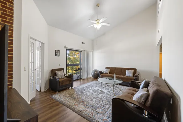 a living room with furniture a large window and a flat screen tv