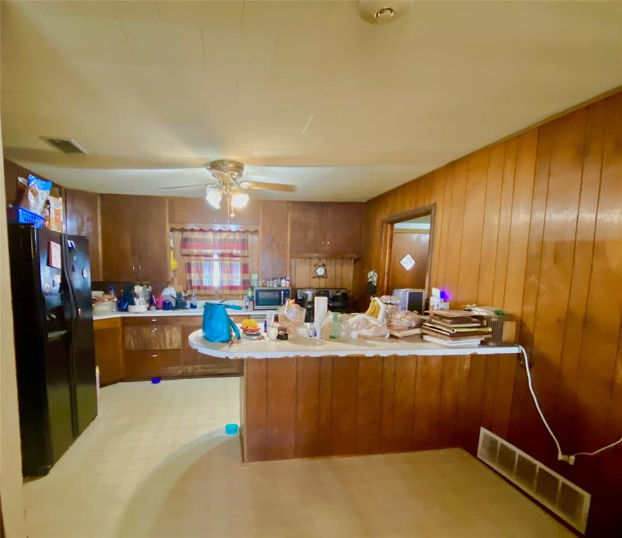403 Mockingbird Street Chico, TX 76431 - Photo 6 of 25 a view of a kitchen with kitchen island a stove a refrigerator a dining table and chairs