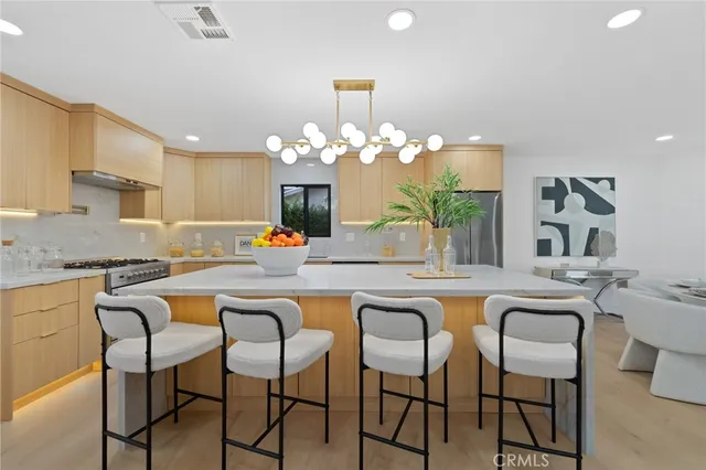 a dining table chairs and chandelier