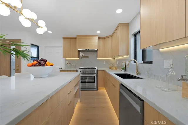 a kitchen with stainless steel appliances granite countertop a sink stove and refrigerator