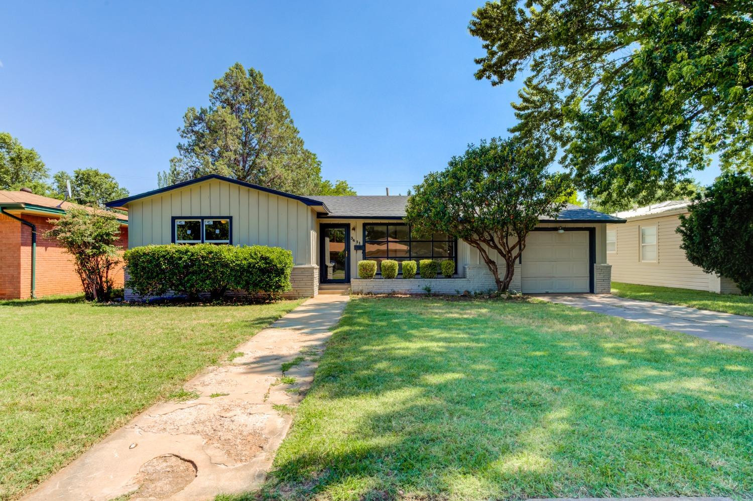 3411 41st Street Lubbock, TX 79413 - Photo 1 of 29 a front view of a house with a yard and garage