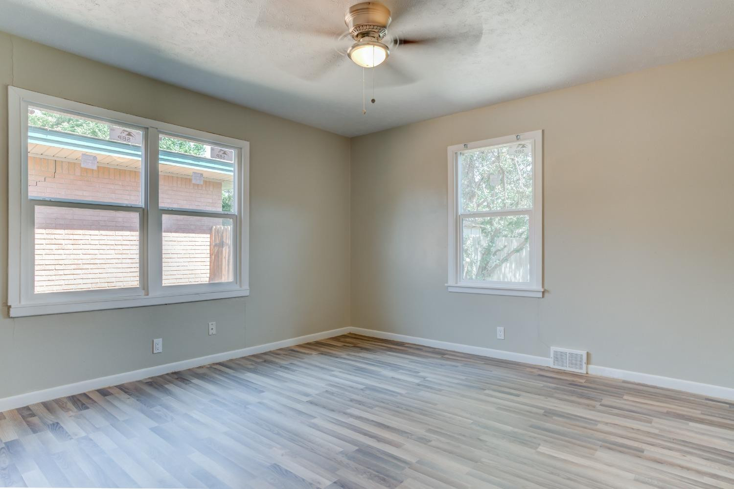 3411 41st Street Lubbock, TX 79413 - Photo 19 of 29 a view of an empty room with wooden floor and a window