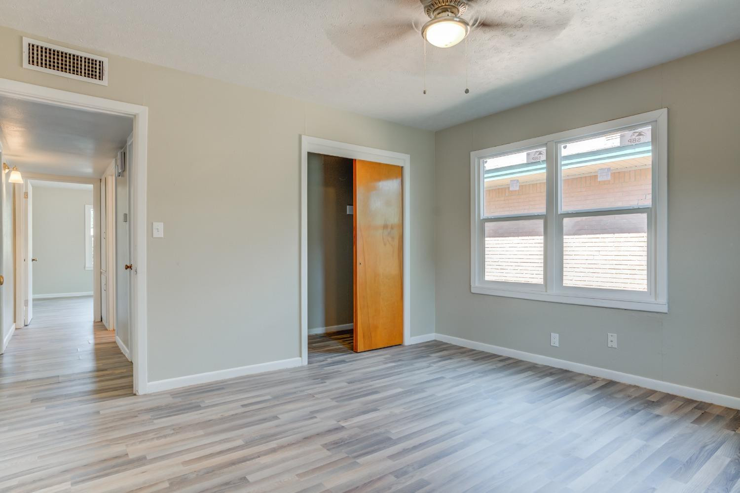 3411 41st Street Lubbock, TX 79413 - Photo 20 of 29 a view of an empty room with wooden floor and a window