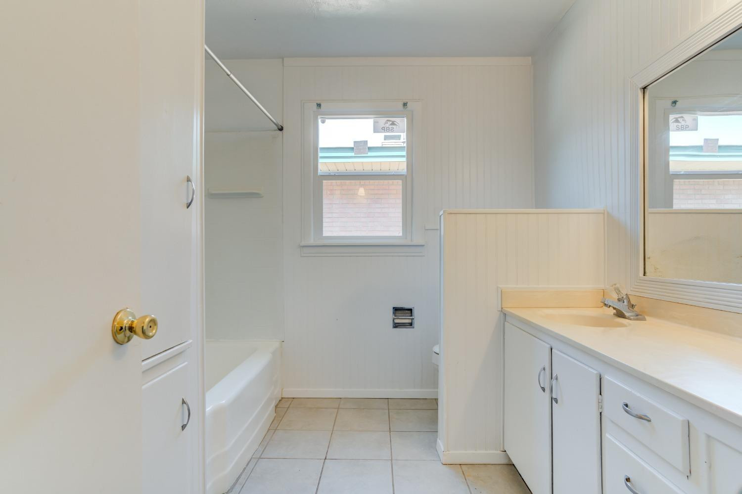 3411 41st Street Lubbock, TX 79413 - Photo 21 of 29 a bathroom with a tub sink and mirror