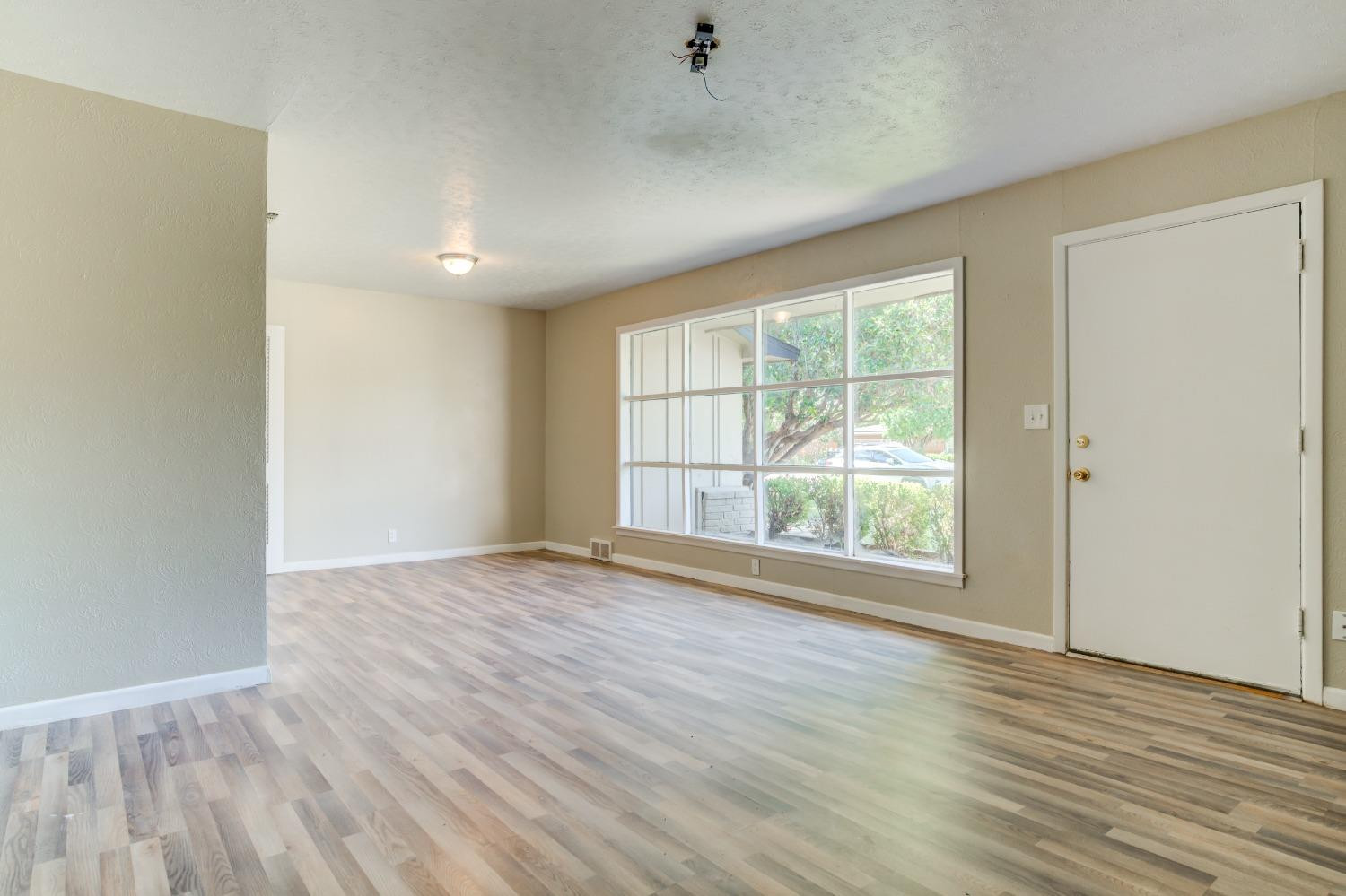 3411 41st Street Lubbock, TX 79413 - Photo 5 of 29 wooden floor in an empty room with a window