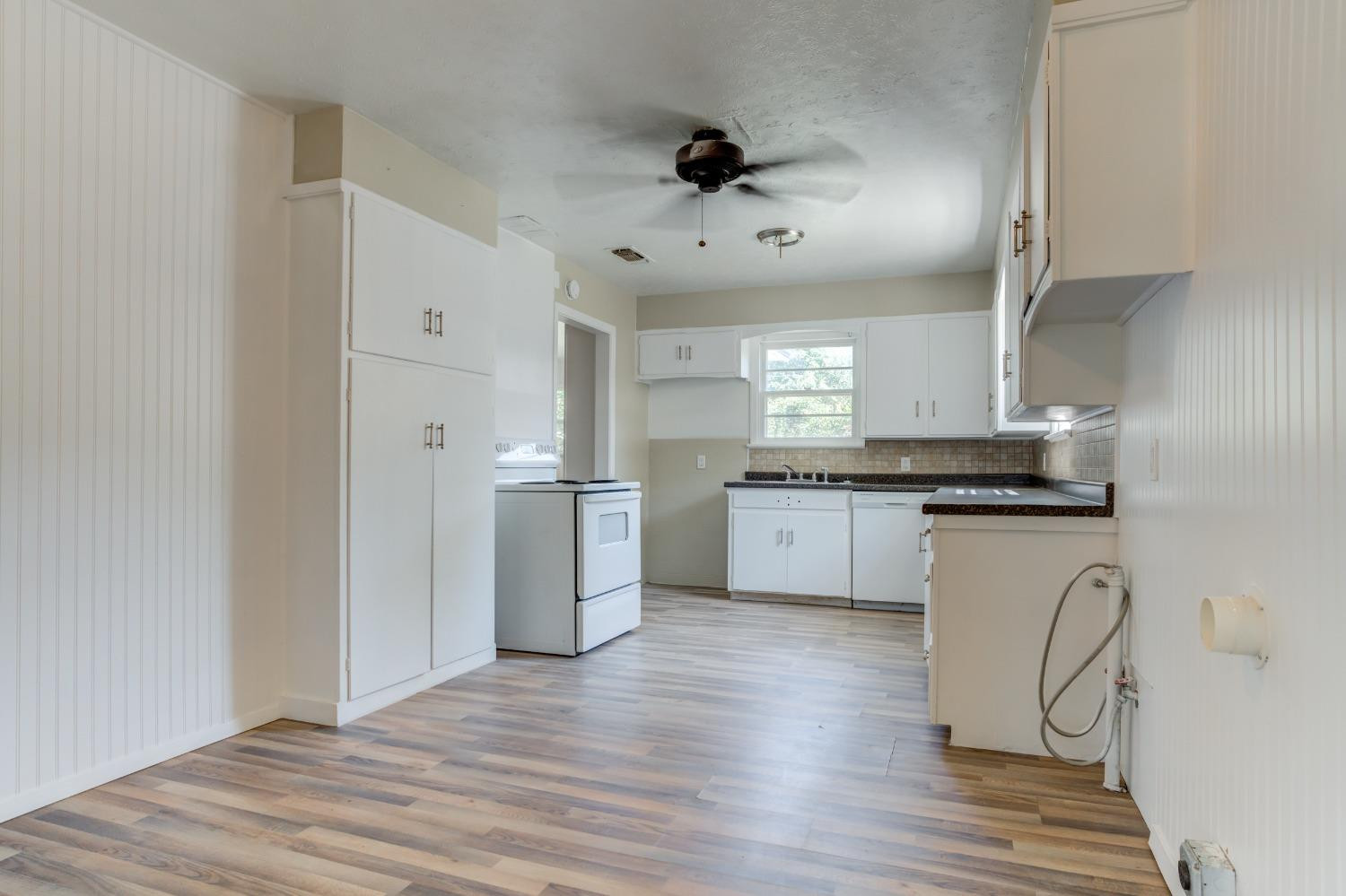 3411 41st Street Lubbock, TX 79413 - Photo 6 of 29 a kitchen with a white cabinets stove and refrigerator