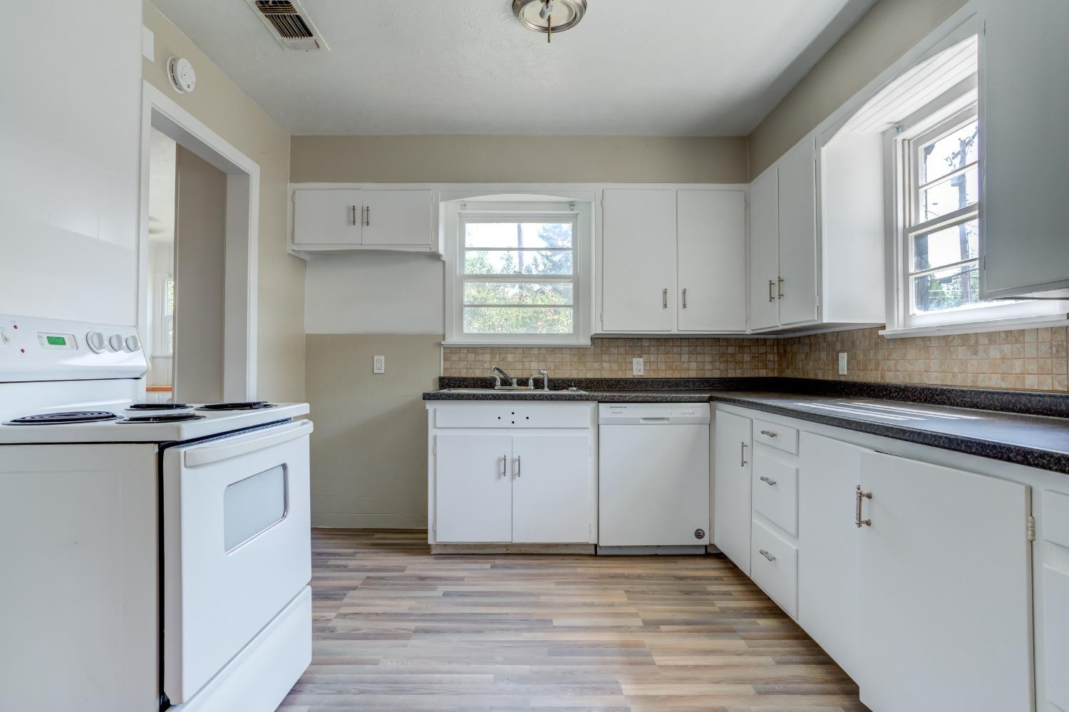 3411 41st Street Lubbock, TX 79413 - Photo 7 of 29 a kitchen with granite countertop cabinets stainless steel appliances a sink and a window