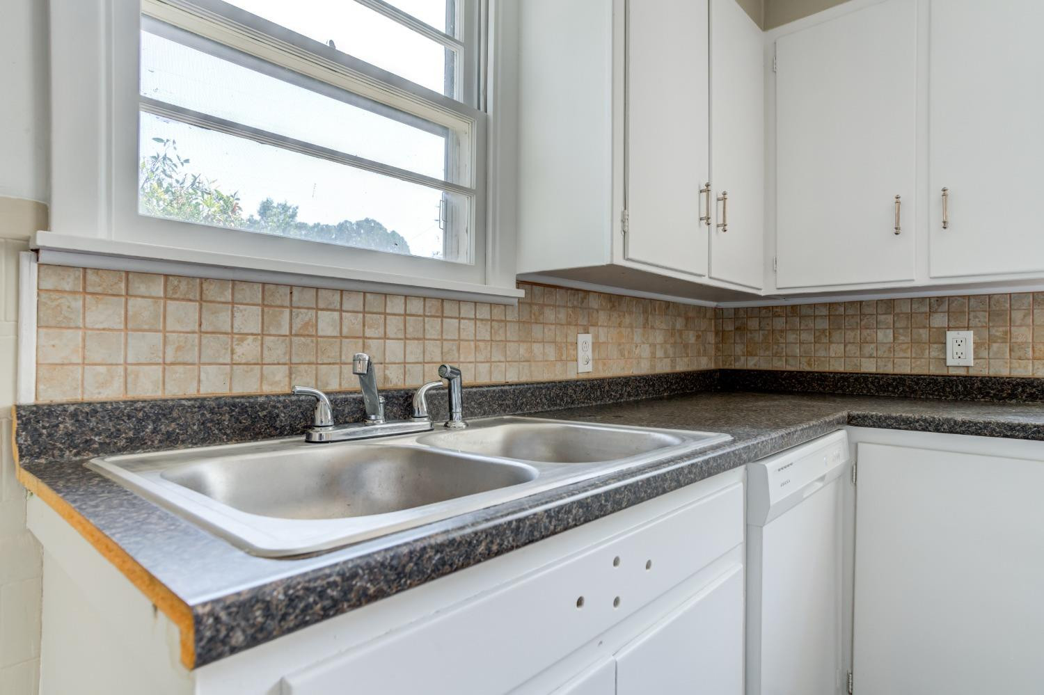 3411 41st Street Lubbock, TX 79413 - Photo 9 of 29 a kitchen with granite countertop a sink and a window