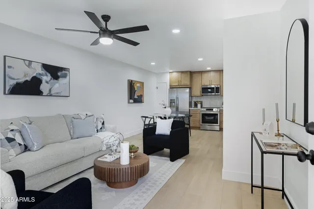a living room with furniture kitchen view and a window