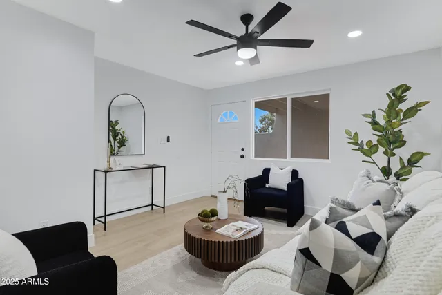 a living room with furniture a window and a potted plant