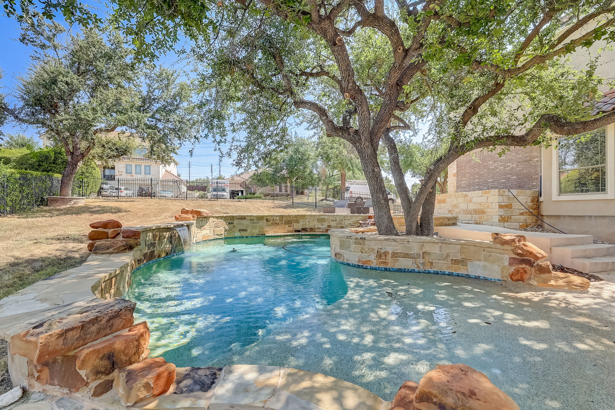 16012 Spillman Ranch Loop Austin, TX 78738 - Photo 38 of 38 A tranquil oasis awaits, complete with a rock-lined pool and a cascading waterfall feature.