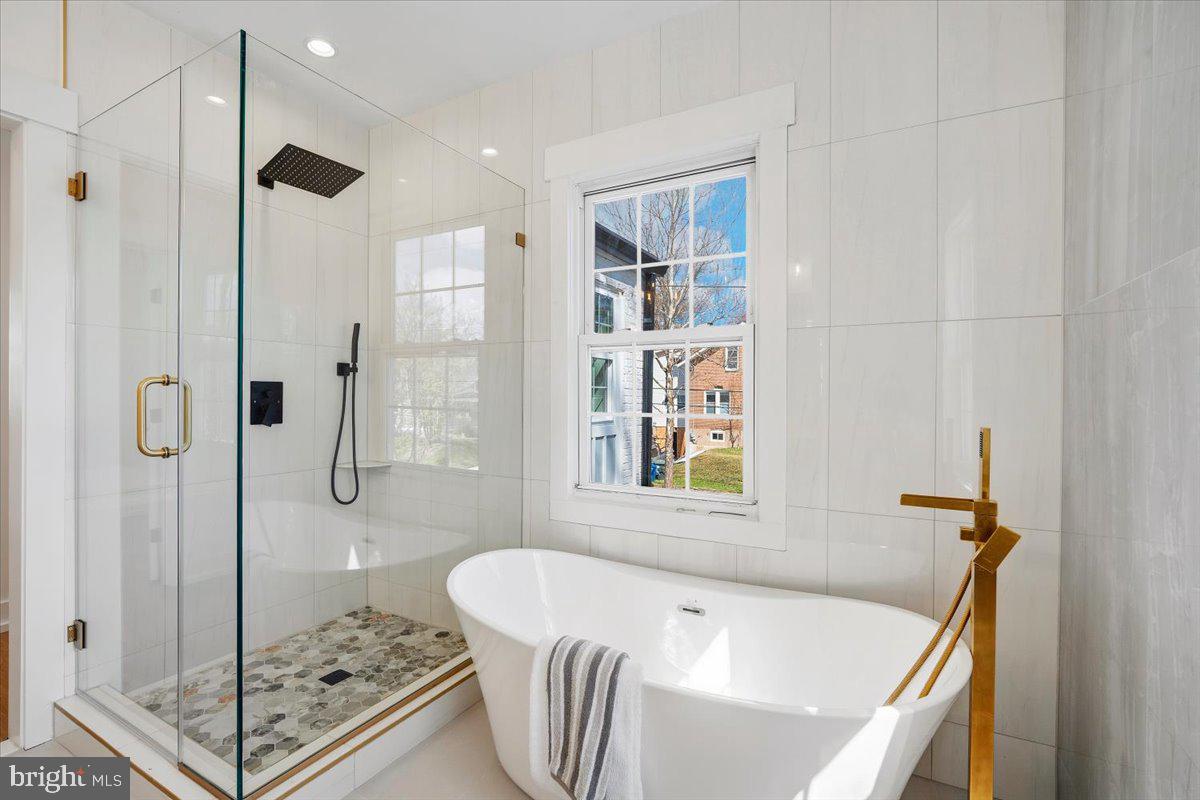 800 Elder Street Northwest Washington, DC 20012 - Photo 10 of 56 a bathroom with a tub a window and a glass door shower