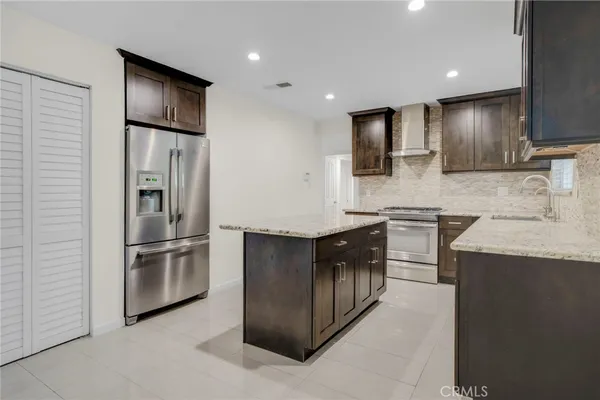 a kitchen with stainless steel appliances granite countertop a refrigerator a sink and a stove