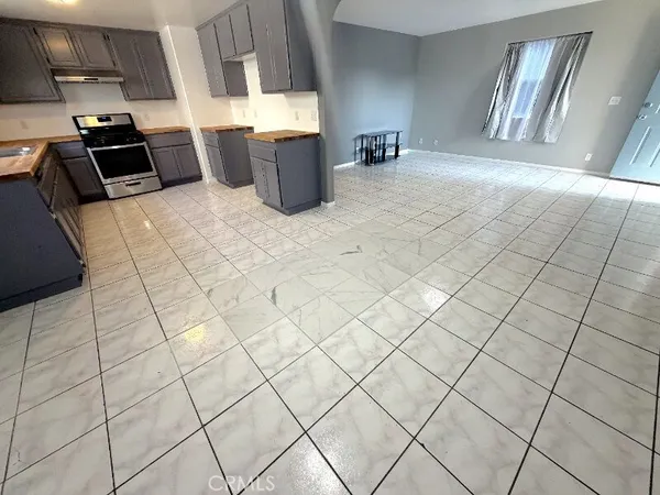a kitchen with stainless steel appliances a sink a stove top oven a counter space and cabinets