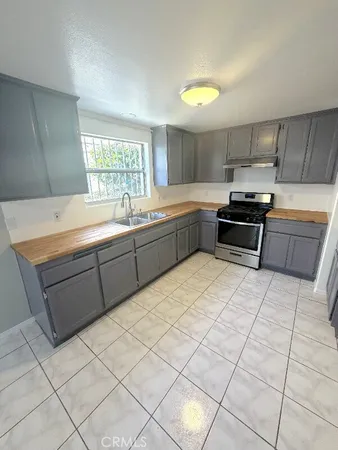 a kitchen with granite countertop a sink and a stove top oven