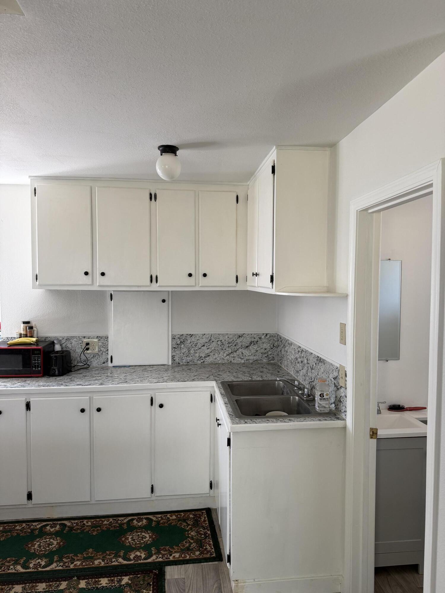 56758 Whitmore Street Bly, OR 97622 - Photo 7 of 12 a kitchen with granite countertop white cabinets and white appliances
