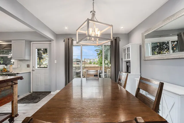 a view of a dining room with furniture a chandelier and wooden floor
