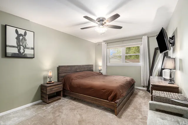 a bedroom with a bed and a flat tv screen on a dresser