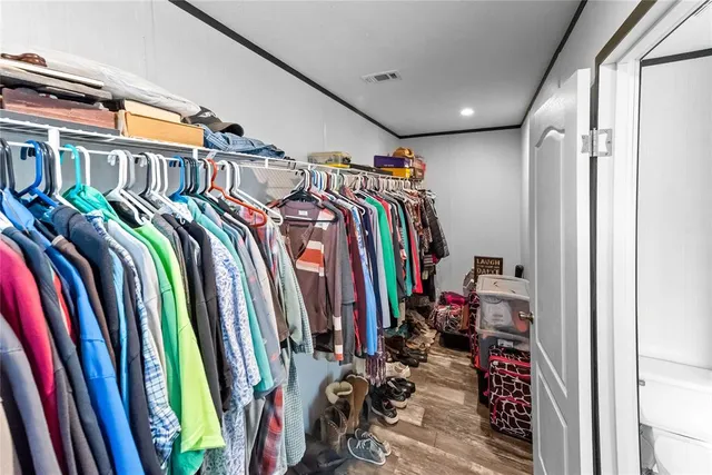 a view of walk in closet with clothes