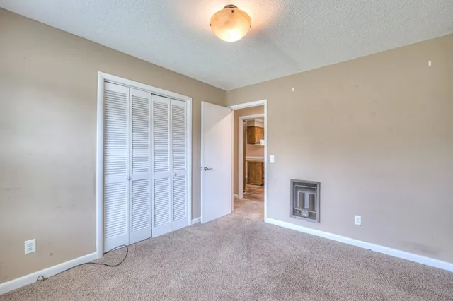 an empty room with closet and a chandelier fan