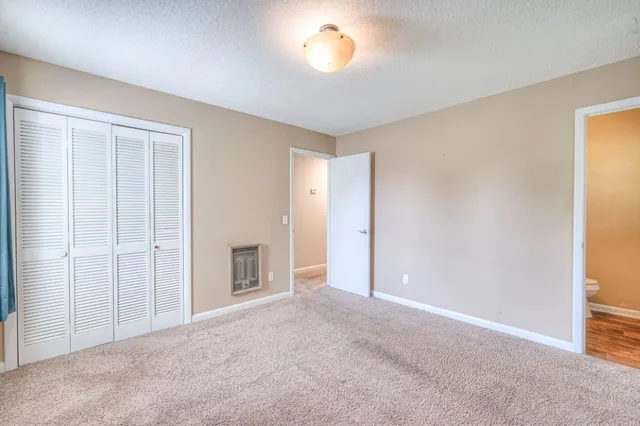 an empty room with windows and closet