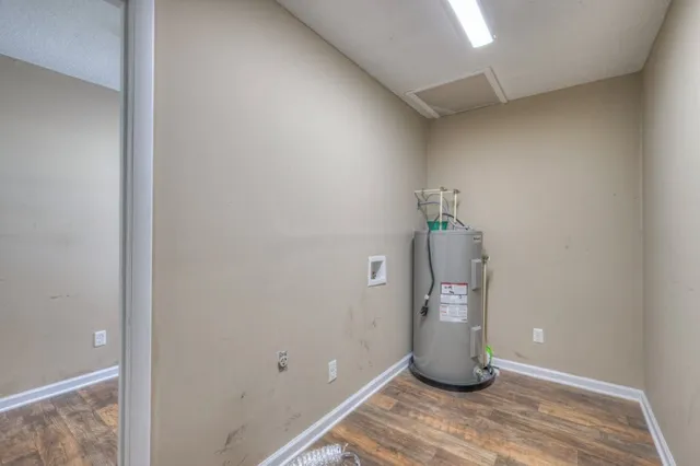 a view of a hallway to wooden floor and cabinet
