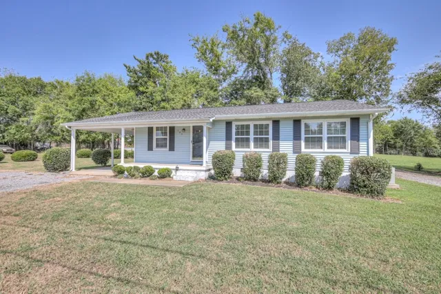 a front view of house with yard and trees