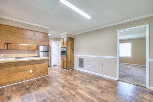 a view of kitchen with refrigerator stove and wooden floor