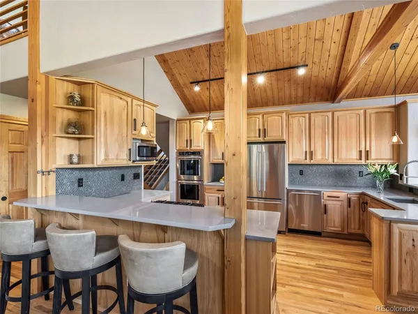 a kitchen with stainless steel appliances granite countertop a sink refrigerator and cabinets