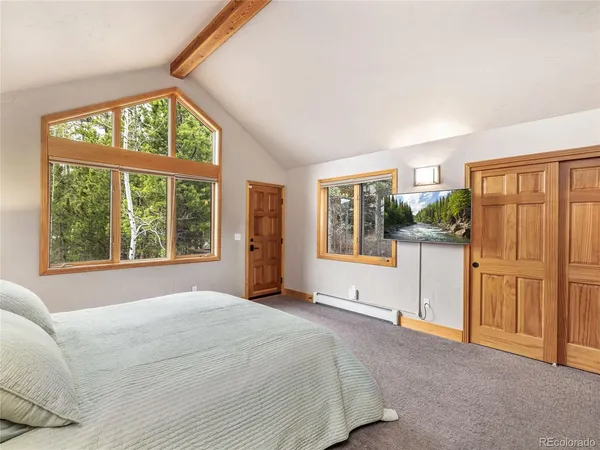 a spacious bedroom with a large window and a balcony