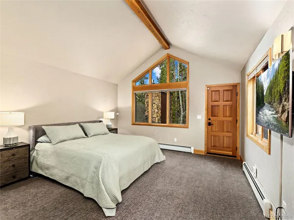 a bedroom with a large bed and a window