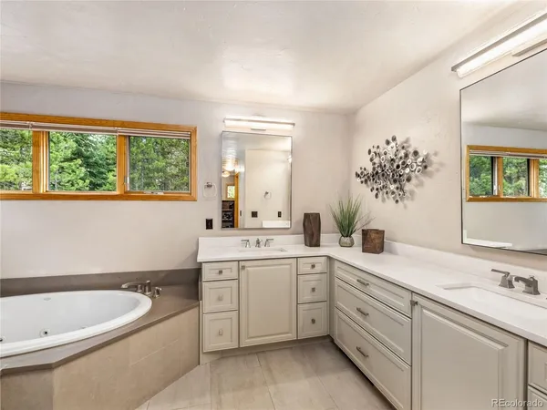 a spacious bathroom with a granite countertop sink and a bathtub