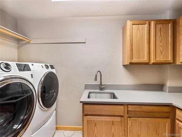 a utility room with sink dryer and washer
