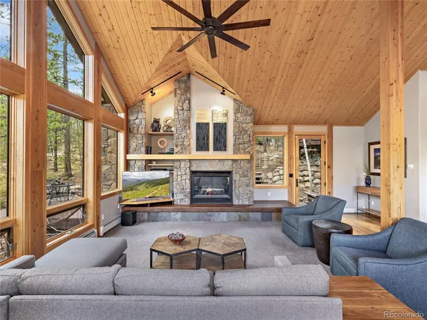 a living room with furniture a fireplace and a large window