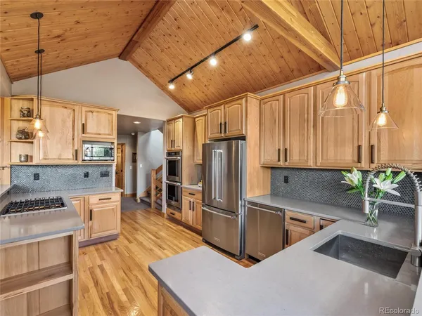 a kitchen with stainless steel appliances a sink a stove and a refrigerator